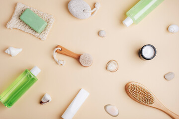 Fototapeta na wymiar Cosmetic flat lay on neutral beige background. Shower gel, bath foam, body brush, face cream, natural soap, pumice stone and body lotion. Spa and wellness concept. Top view