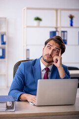 Young male employee and too much work in the office