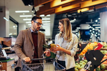 Lovely couple buying fruit in nearby grocery