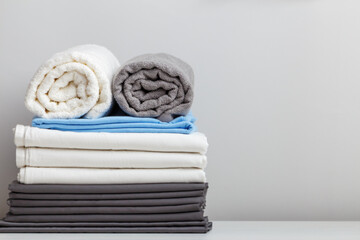 A stack of bed linen, sheets and towels on the table. copy space