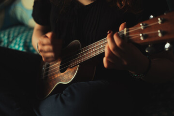 Fototapeta premium Mujer tocando ukulele en su habitación. Concepto de musica.