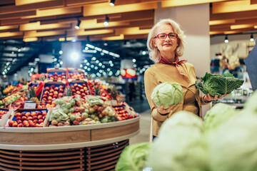 Mature woman buying vegetables in supermarket