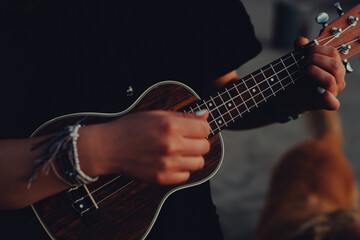 detalle de manos tocando el ukulele. Concepto de musica.