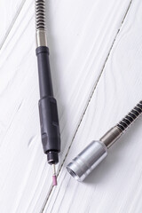 Naklejka premium dremel. precise and accurate processing of the product. on a wooden background in retro style. white color