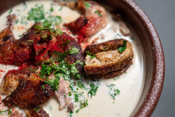 closeup of georgian chkmeruli chiken meat with cream sauce and cilantro in bowl 