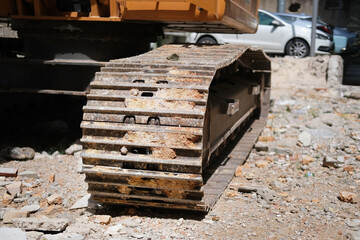 Caterpillars of a construction excavator in the sand at a construction site