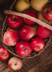 Fresh ripe red apples in a wicker basket on a wooden background. Organic raw food. Vegan concept. Healthy eating concept.