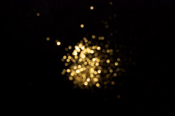 Golden blurred bokeh lights on black background. Glitter sparkle stars for celebrate. Overlay for...