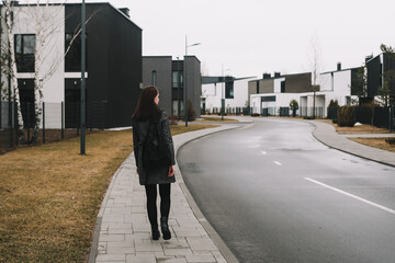 young woman walks through the street in spring.