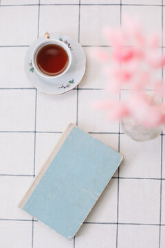 modern interior design of a cozy living room with dry plants in vase, book and tea cup on the table 