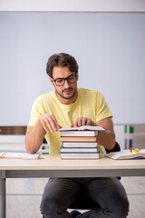 Young male student preparing for exams in the classroom