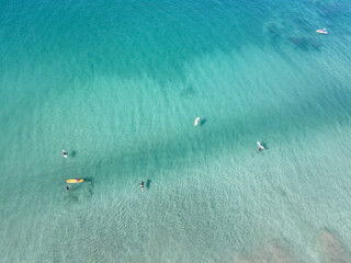 Surfers in turquoise waters of Playa Negra, Costa Rica.