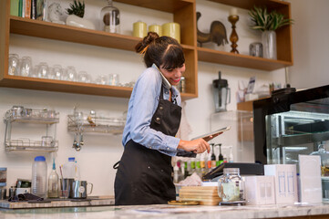 Young service minded barista woman working in coffee shop
