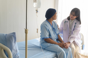 Doctor holding senior cancer patient's hand in hospital, health care and medical concept..