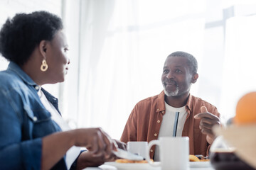 senior african american man talking with wife during breakfast.