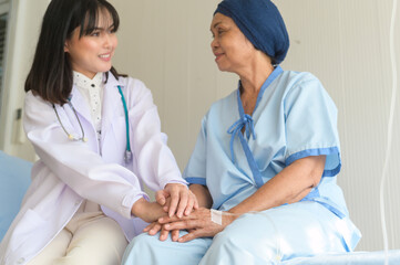 Doctor holding senior cancer patient's hand in hospital, health care and medical concept..