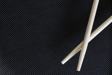 Sushi sticks on a black background with an empty space. The concept of food. Japanese cuisine. Background for websites, posters, postcards
