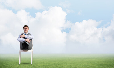 scared businessman on a chair