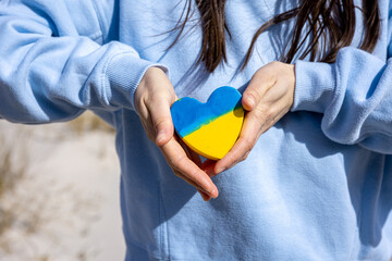Close-up, heart in the color of the flag of Ukraine in female hands.