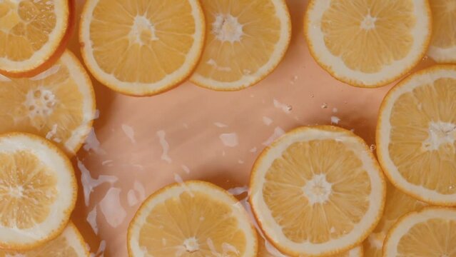 Falling of orange slice into water, top view