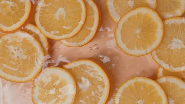 Falling of orange slice into water, top view