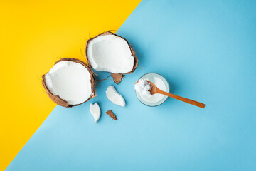 Cracked coconut with pieces on the yellow and blue background