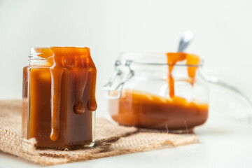 Salted caramel in the glass jar on the white background