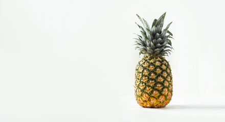 Whole pineapple isolated on the white background with copy space for text. Summertime background with tropic feel