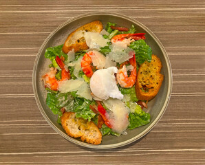A caesar salad with prawns in a dish