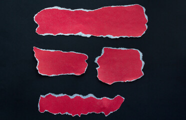 four pieces of red paper on a black background