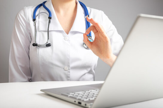 Online medical consultation concept. Doctor with stethoscope speaking to patient through video chat and showing ok gesture. Telemedicine, telehealth concept. High quality photo