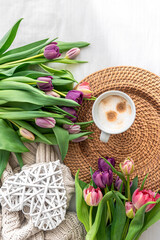 Cozy composition with flowers and coffee on a white background, top view.