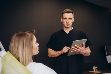 Friendly doctor and patient woman discussing current health examination while sitting in sunny...