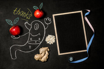 Good digestion concept. A funny stomach drawn on a chalk board next to apples and gingerbread....