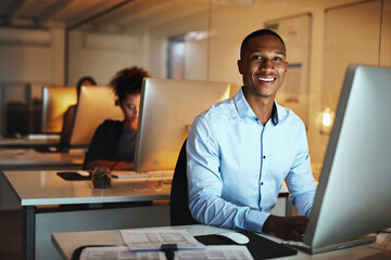 Here to get ahead of my deadlines. Portrait of a young businessman working late on a computer in an office.