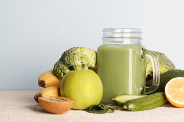 fresh green smoothie in glass bottle with vegetables on blue background.vegan food, self care and healthy lifestyle.Healthy detox diet