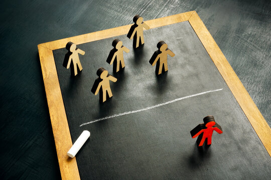 Social exclusion concept. Figurines and a chalk line separating them.
