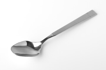 Stainless steel teaspoon on a white background. Close-up