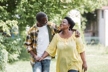happy senior african american couple walking in park.