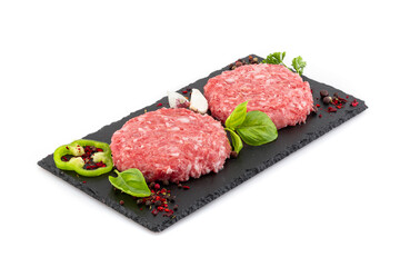 Uncooked minced meat patties on black board