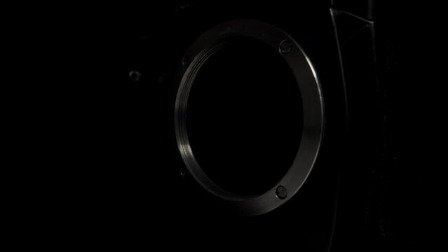 Old SLR, film camera, on a black background.