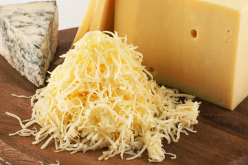 Garganzola cheese and freshly grated parmesan cheese on a wooden table.