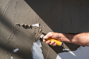 Trabalhador a colocar cimento na parede para rebocar a mesma