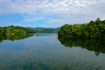 Calm view of dam water surrounded with green trees in Kuala Kubu Bharu, Selangor, Malaysia.