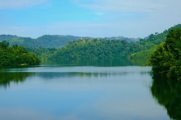 Obraz premium Calm view of dam water surrounded with green trees in Kuala Kubu Bharu, Selangor, Malaysia.