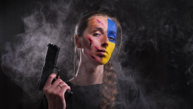 the girl in the smoke turns and raises the gun, one part of her face is bloody with wounds and the second part of her face is the color of the flag of Ukraine