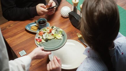 Scanning QR code in restaurant. Woman eating salad, using qr code with smartphone, online menu in cafe. Modern technology, ordering meal in application. Contactless touch-free payment in app. - Powered by Adobe