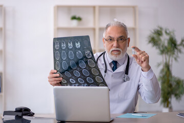 Old male doctor radiologist working in the clinic
