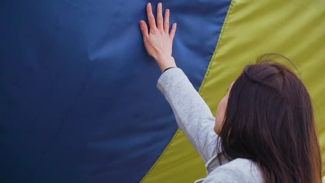 Ukrainian woman raised her hand to national flag during state invasion and fighting for freedom and independence. Crisis, peace, stop aggression in whole world