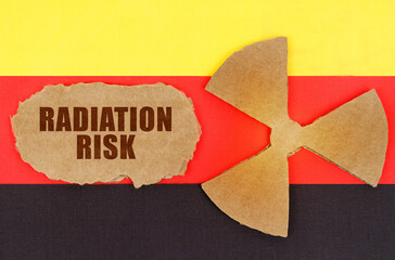 On the flag of Germany, the symbol of radioactivity and torn cardboard with the inscription -...
